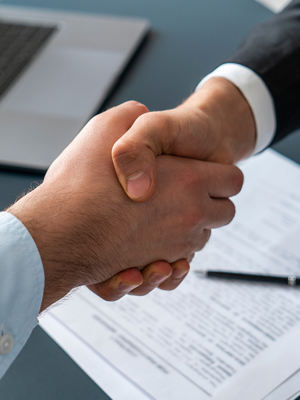 Picture of a handshake above a contract sheet