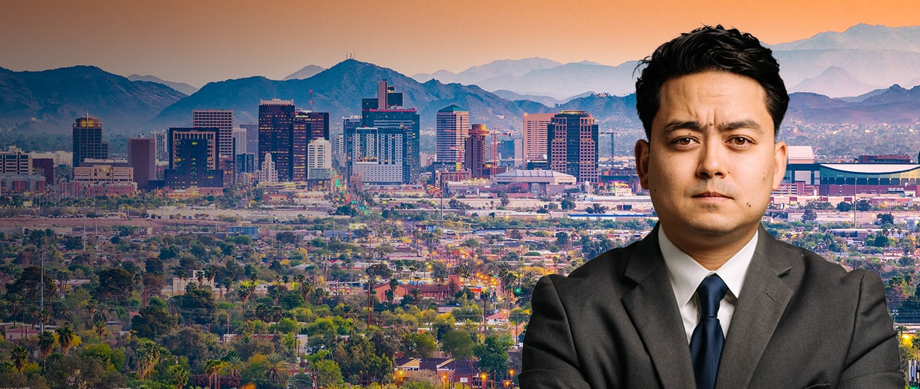 Picture of attorney in front of a photo of Arizona buildings