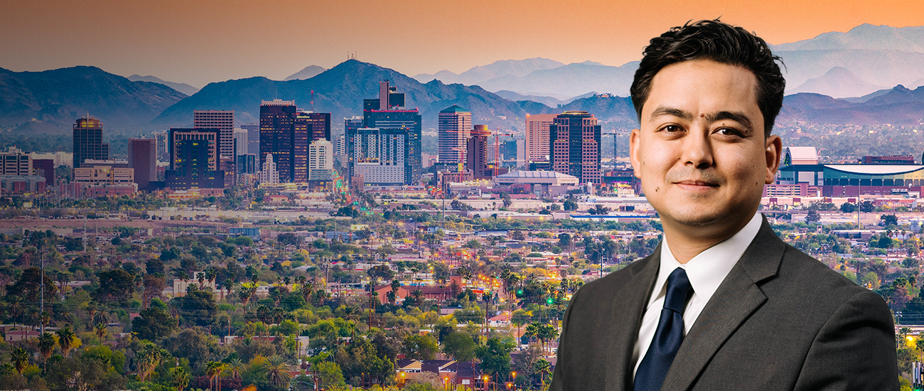 Picture of attorney in front of a photo of Arizona buildings